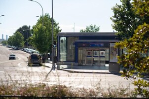 Eine Bushaltestelle mit Unterstand, eine Ampel und eine Straße mit Autos.
