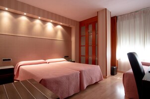 Ein Hotelzimmer mit einem großen Bett, einem Schreibtisch und einem Stuhl.