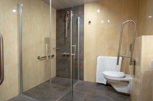 Ein modernes Badezimmer mit einer Duschkabine, Toilette und Handtuchhalter.