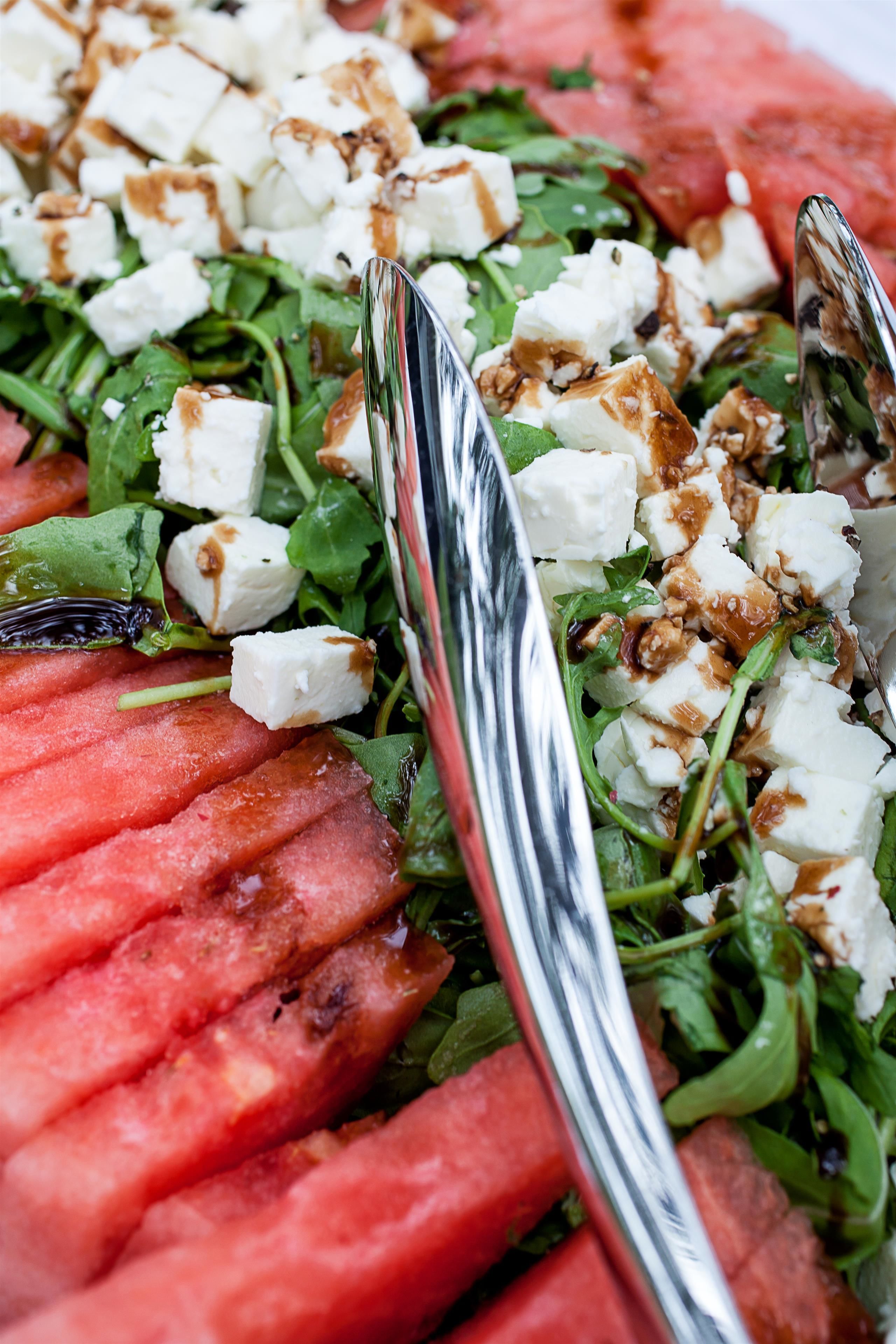 Une vue rapprochée d’une salade composée de pastèque, de fromage feta et de noix.