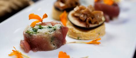 Un plato blanco con diferentes alimentos, entre ellos un trozo de carne y un plato redondo en capas.
