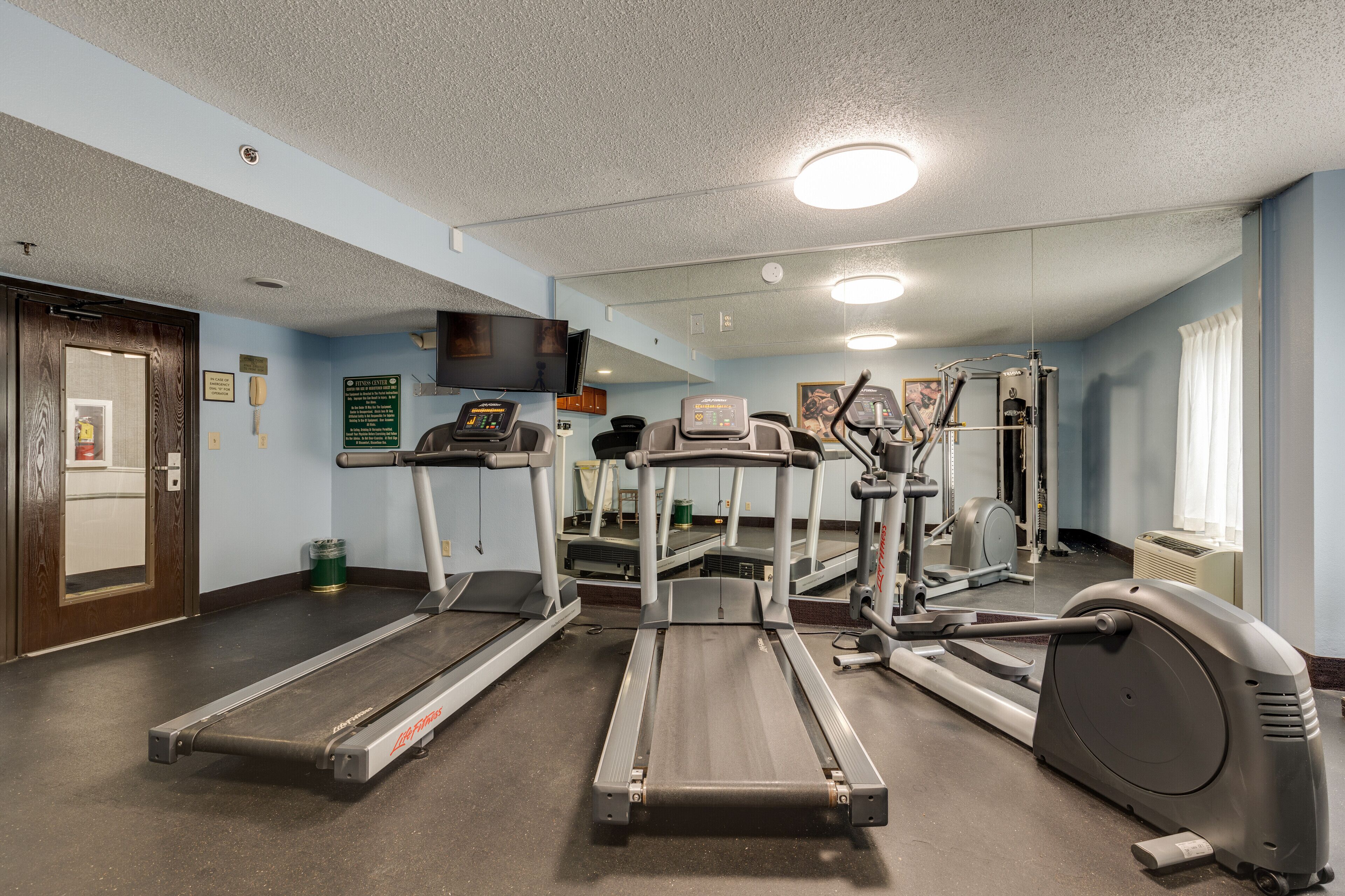Un centre de remise en forme équipé de tapis de course, de vélos elliptiques et d’un vélo d’appartement.