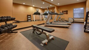A gym with treadmills, a bench press, and a rack of dumbbells. - Mishawaka Inn (Mishawaka)