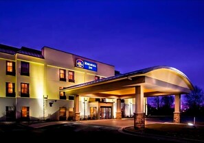 A hotel with a covered entrance, a signboard, and a well-lit facade. - Mishawaka Inn (Mishawaka)