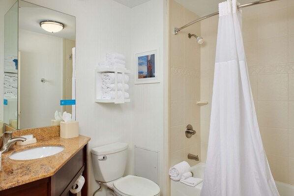 A bathroom with a sink, toilet, and shower curtain.