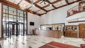 A spacious lobby with a reception desk, a chandelier, a clock, and a staircase. - Econo Lodge Truman Inn (Sedalia)