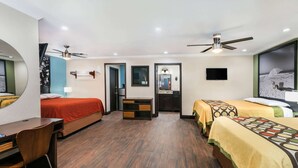 A hotel room with two beds, a desk, a chair, a TV, and a ceiling fan. - Super 8 by Wyndham Austin University/Downtown Area (Austin)