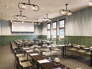 A conference room with long tables, chairs, and a large screen. - Chaminade Resort & Spa (Santa Cruz)
