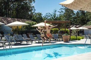 Une piscine avec des chaises longues et des parasols.
