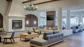 A spacious living area with a fireplace, seating, and a television.