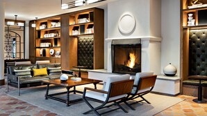 A modern living room with a fireplace, leather furniture, and built-in bookshelves. - Chaminade Resort & Spa (Santa Cruz)