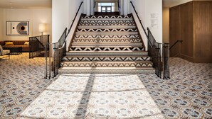 A grand staircase with patterned tiles, wooden beams, and a skylight. - Chaminade Resort & Spa (Santa Cruz)