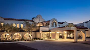 Experience the unique blend of modern and traditional architecture at this hotel, featuring a striking arched entrance and large windows.