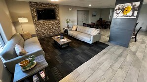 Un salón con sofá, mesa de centro y una pared de acento de piedra.