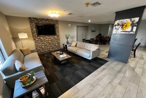 Un salón con sofá, mesa de centro y una pared de acento de piedra.