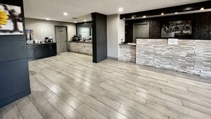 Una cocina moderna con salpicadero de piedra, armarios oscuros y una encimera con varios electrodomésticos.