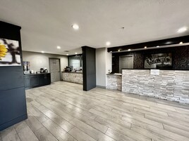 Una cocina moderna con salpicadero de piedra, armarios oscuros y una encimera con varios electrodomésticos.