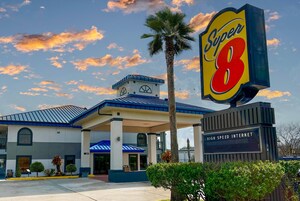 Un hotel con un llamativo letrero de 'Super 8', una entrada cubierta y un letrero que indica 'Internet de alta velocidad'.