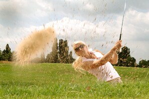 A person playing golf in a grassy field. - Holiday Inn Express Moss Point by IHG (Moss Point)
