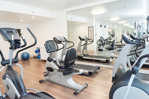 A gym with multiple exercise machines, including treadmills and elliptical trainers, and a large mirror reflecting the equipment. - Holiday Inn Express Moss Point by IHG (Moss Point)