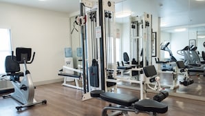 A gym with various exercise equipment, including a treadmill, elliptical, and weight machines. - Holiday Inn Express Moss Point by IHG (Moss Point)