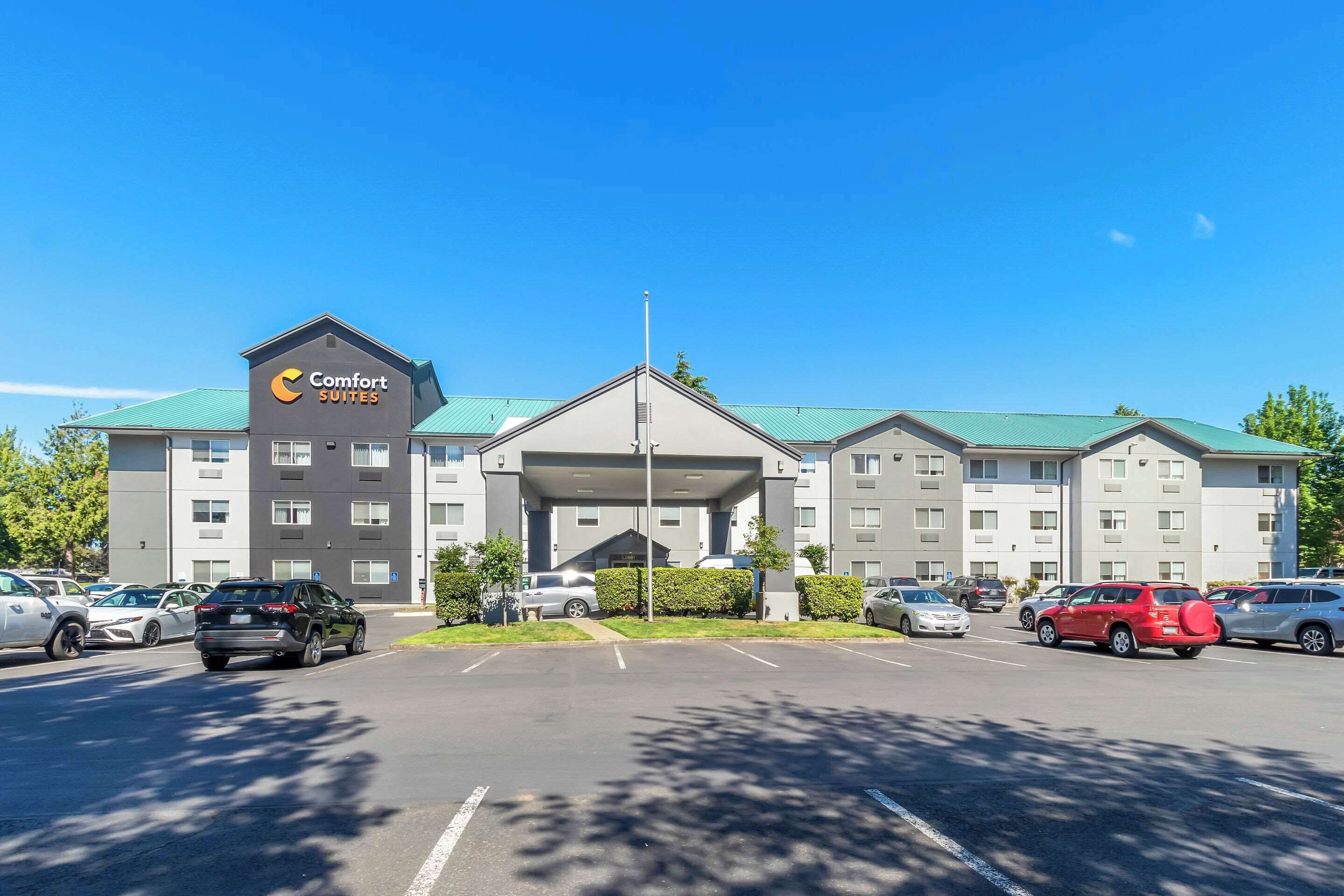 Ein Comfort Suites Hotel mit Parkplatz und mehreren Autos.