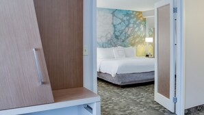 Una habitación de hotel con cama, mesita de noche y pared con diseño texturizado.