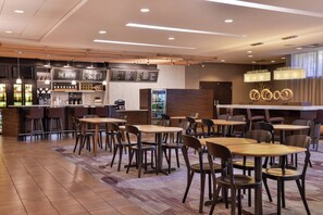A modern bistro with wooden tables and chairs, a bar area, and a menu board. - Courtyard Marriott Ocala (Ocala)