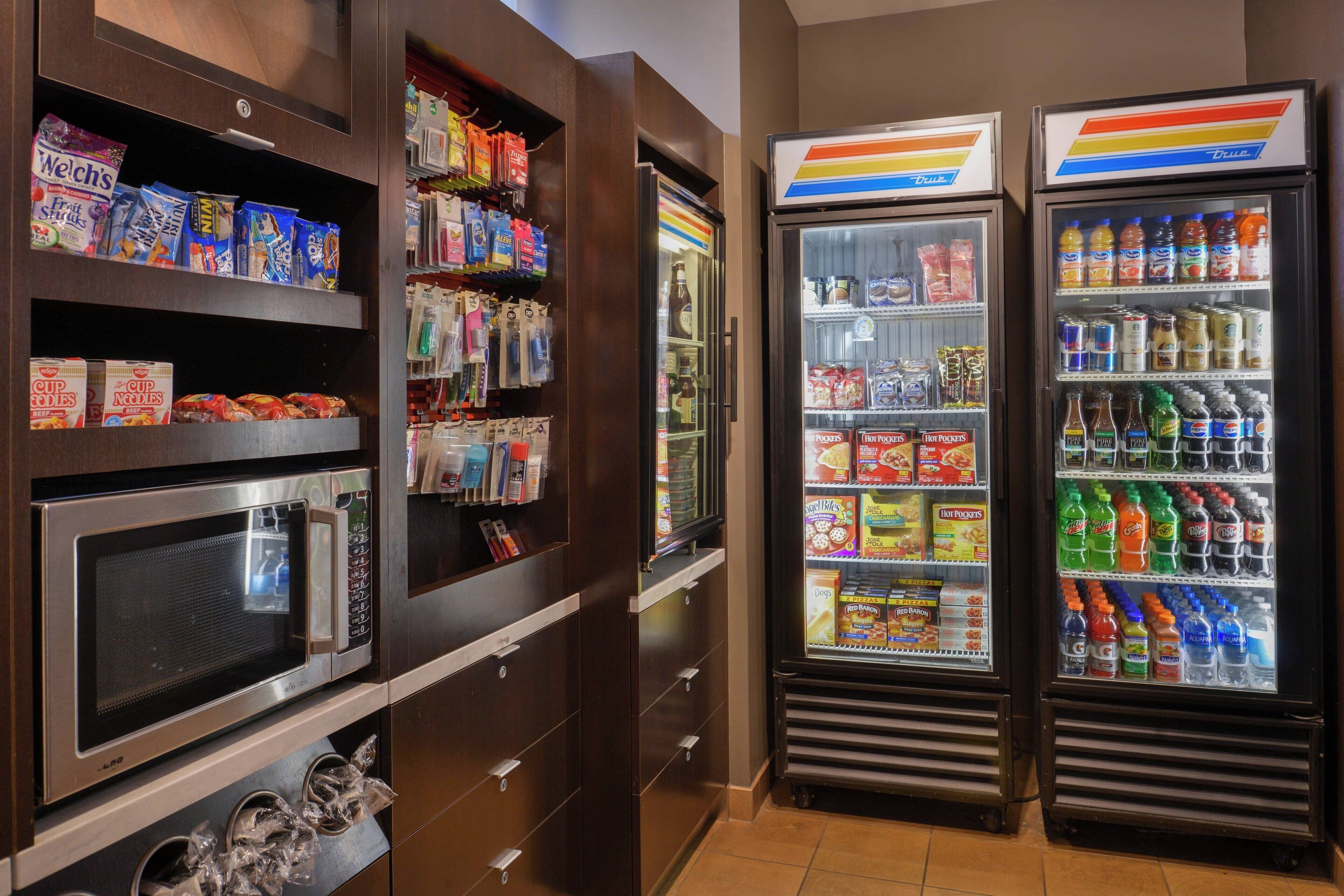 A vending area with microwaves, snack dispensers, and beverage coolers.