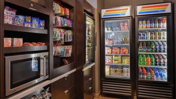 A vending area with microwaves, snack dispensers, and beverage coolers.