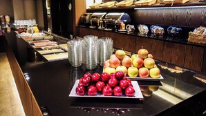 A buffet counter with various food items, including apples and a selection of beverages. - Marivaux Hotel (Brussels)