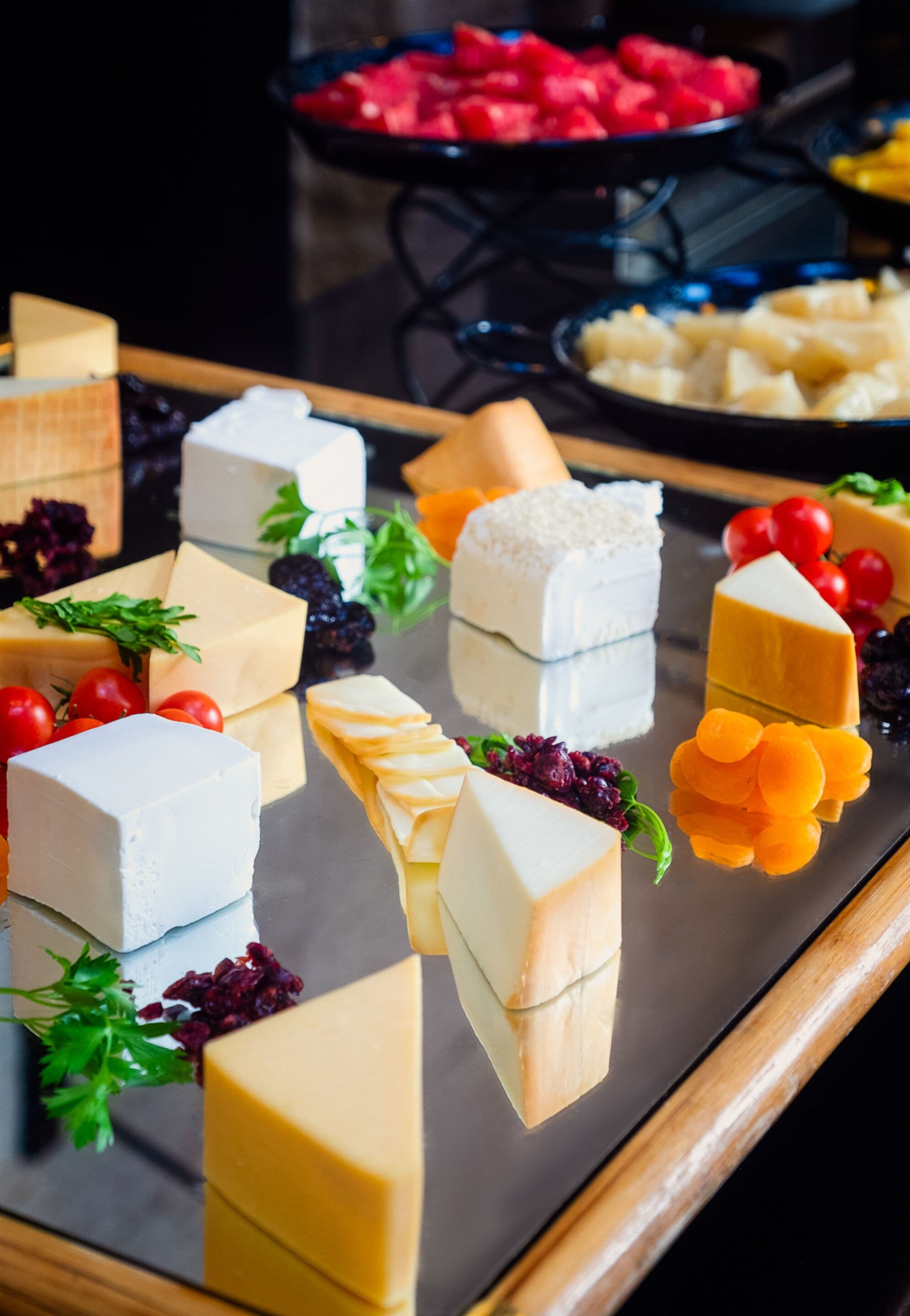 Eine Auswahl an Käse und Obst auf einer Platte.