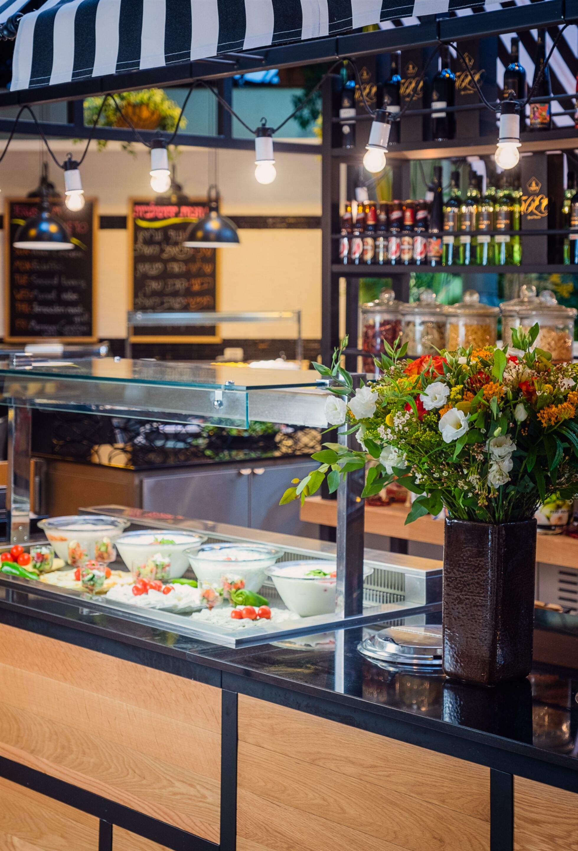 Mostrador de buffet con diferentes alimentos y un arreglo floral.