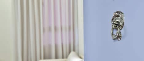 Una habitación con un sofá blanco, un pomo metálico decorativo y el número 518 en la pared.