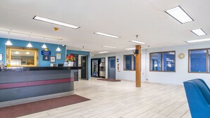 A reception area with a counter, a mirror, and a clock on the wall.