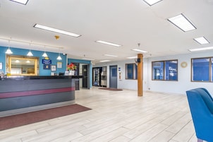 A reception area with a counter, a mirror, and a clock on the wall.