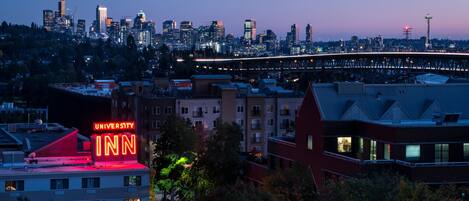 Stadszicht met een opvallend University Inn bord, een brug en een uitzicht op de Seattle Space Needle.