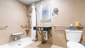Un baño moderno con ducha a nivel de suelo, inodoro y lavamanos.
