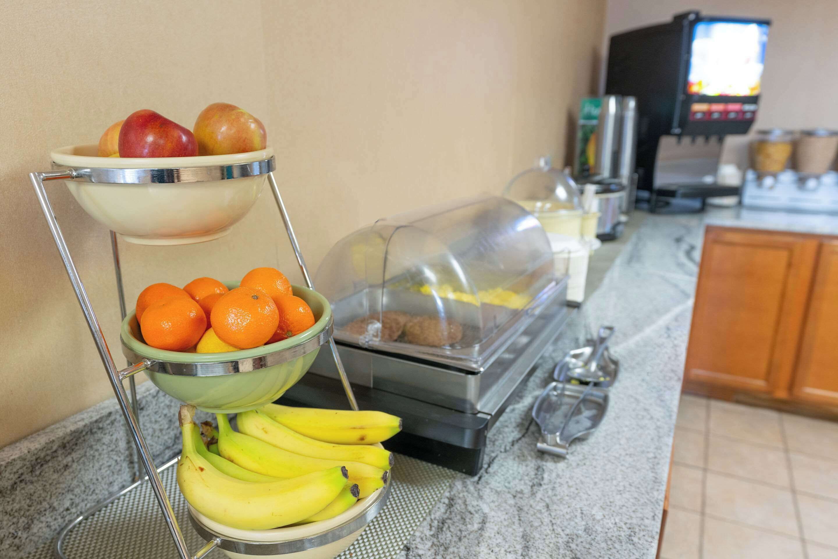 Una mesa de buffet con frutas y una cafetera.