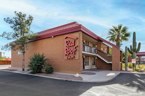 A Red Roof Inn with a red roof, a balcony, and a sign indicating reserved parking.