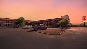 A hotel with a red roof and multiple parking spaces. - Red Roof Inn Tucson South - Airport (Tucson)
