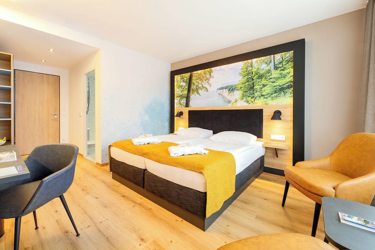 Ropa de cama hipoalergénica y caja de seguridad en la habitación