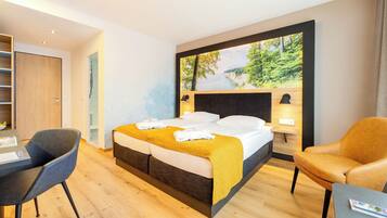 Quarto de hotel moderno com uma cama grande, uma mesa e uma poltrona confortável.