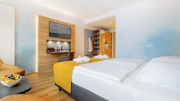 Moderni hotellihuone, jossa on sänky, työpöytä ja oleskelualue.