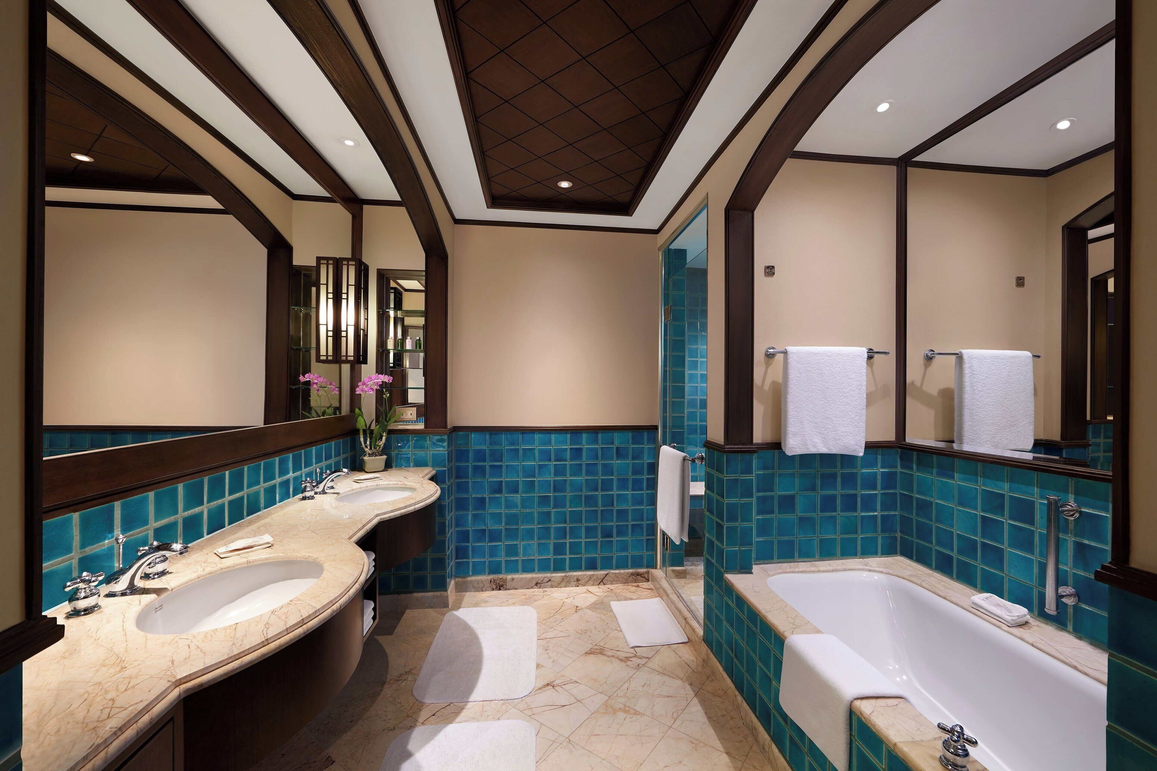 A bathroom with two sinks, a bathtub, and a large mirror.