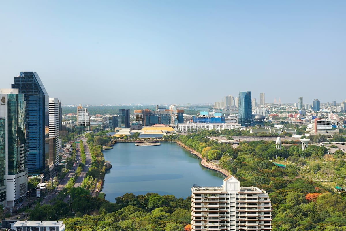 A cityscape with modern buildings, a river, and a park area.