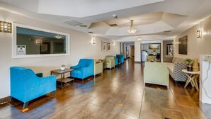 A spacious lobby with a modern design, featuring a mix of seating areas and a visible business center.