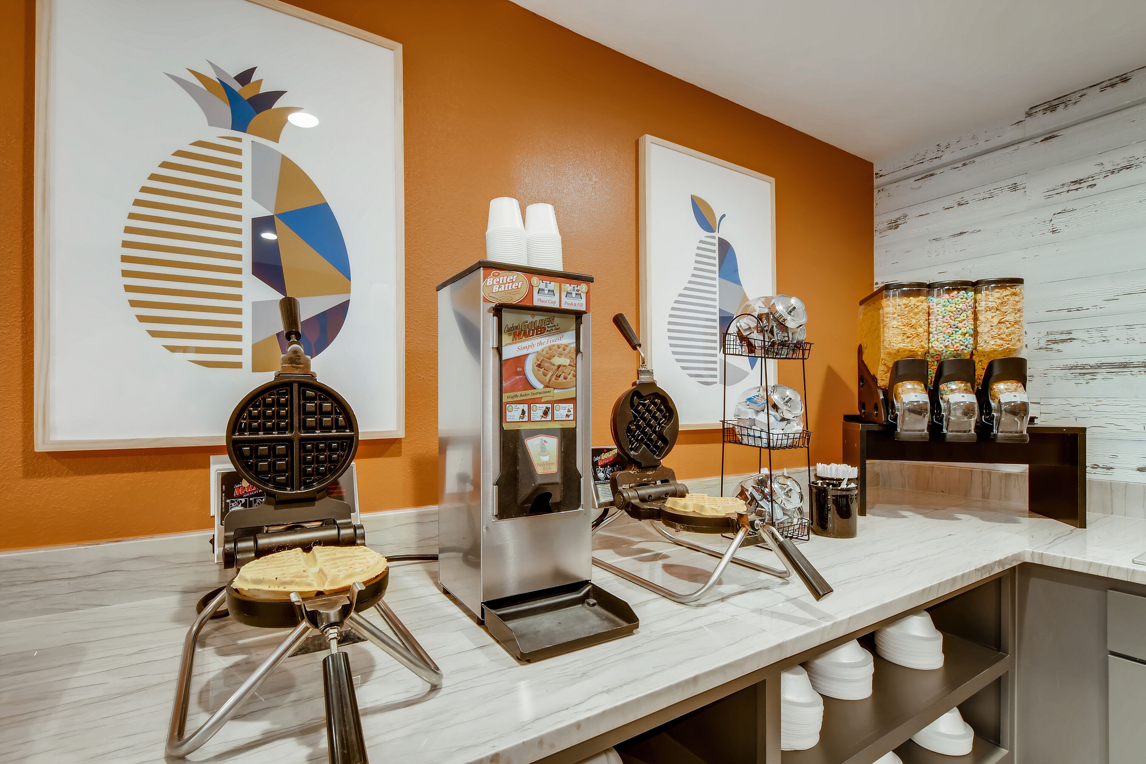 A breakfast bar with waffle makers, a waffle iron, and a waffle maker with a menu.