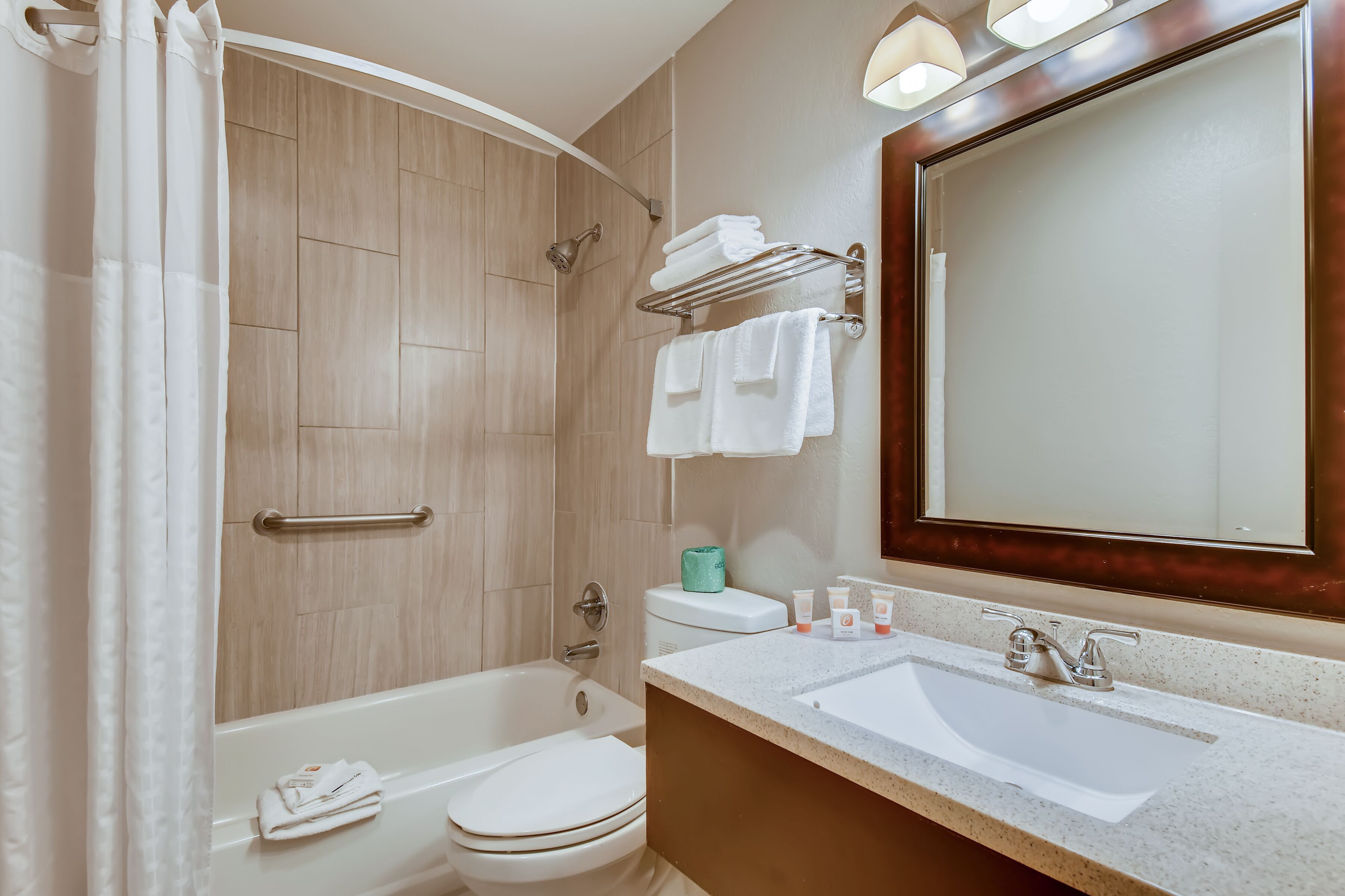 A modern bathroom with a bathtub, toilet, and sink.