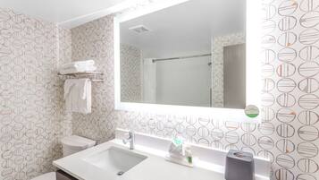 A bathroom with a white sink, a mirror, a towel rack, and a toilet.